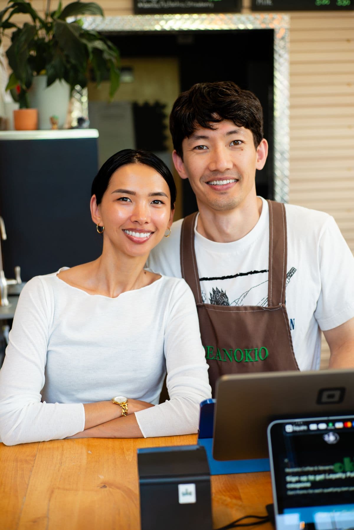 Two coffee shop owners behind their counter